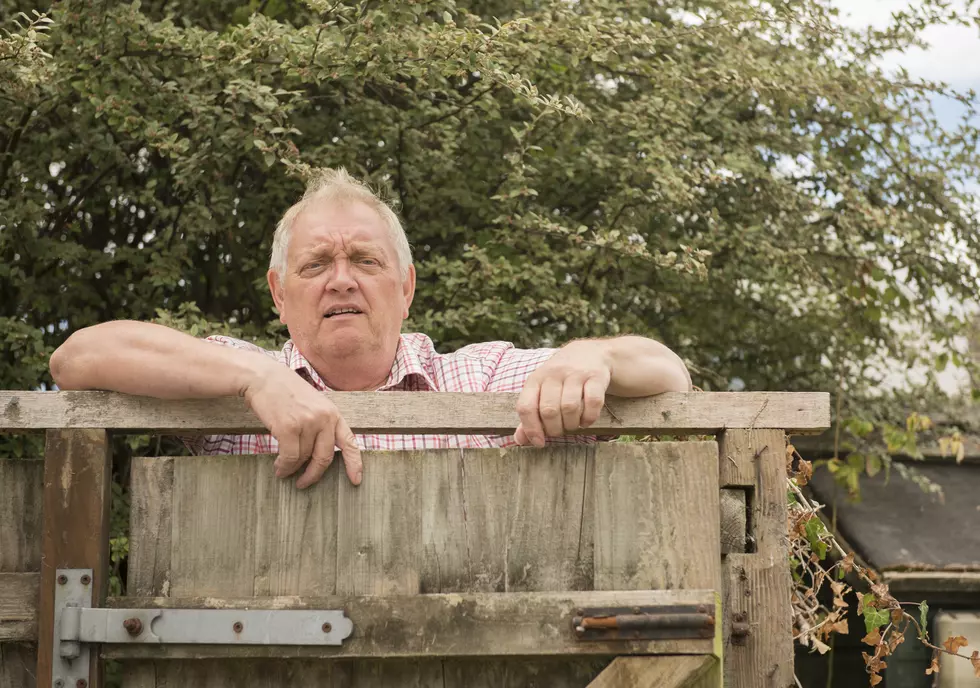 Mature man shouting over a fence