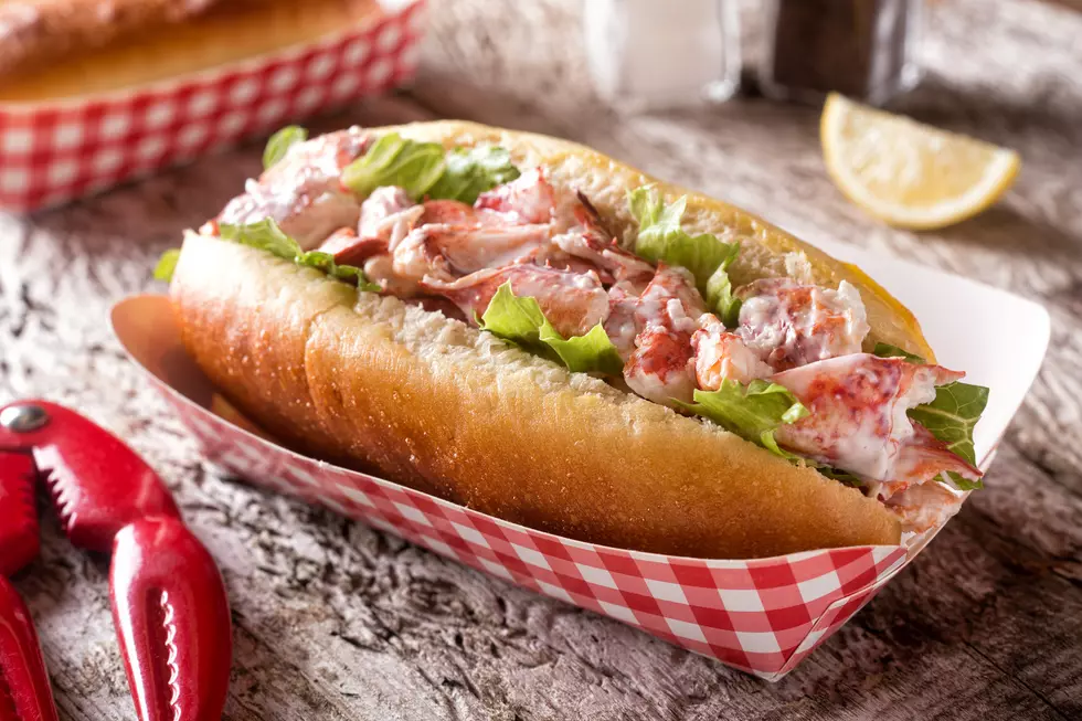 A delicious lobster roll on a rustic wood table top.