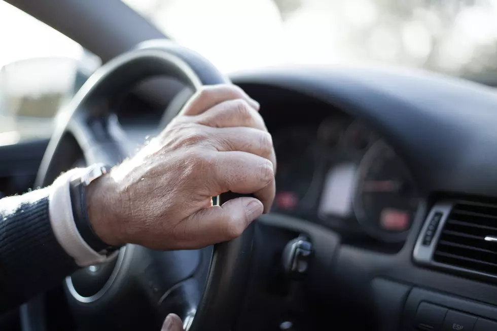 Senior man hand detail while driving a car. Soft focus. Vintage tone.