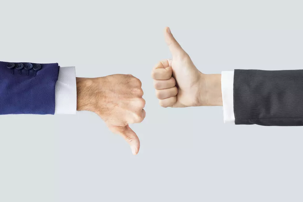 Hands making thumbs up and down