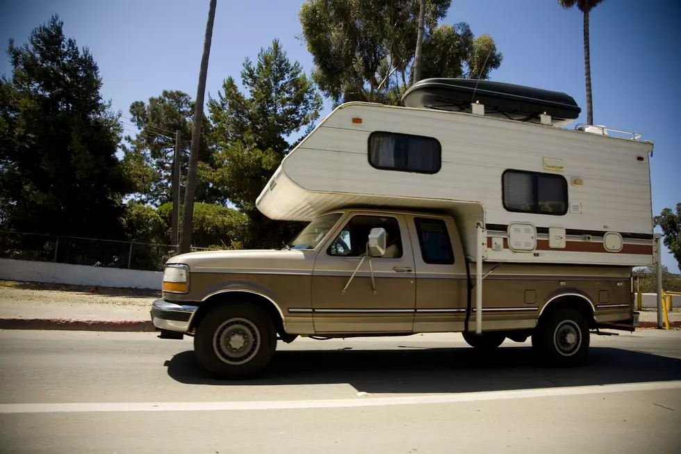 Old truck with a camper attached.