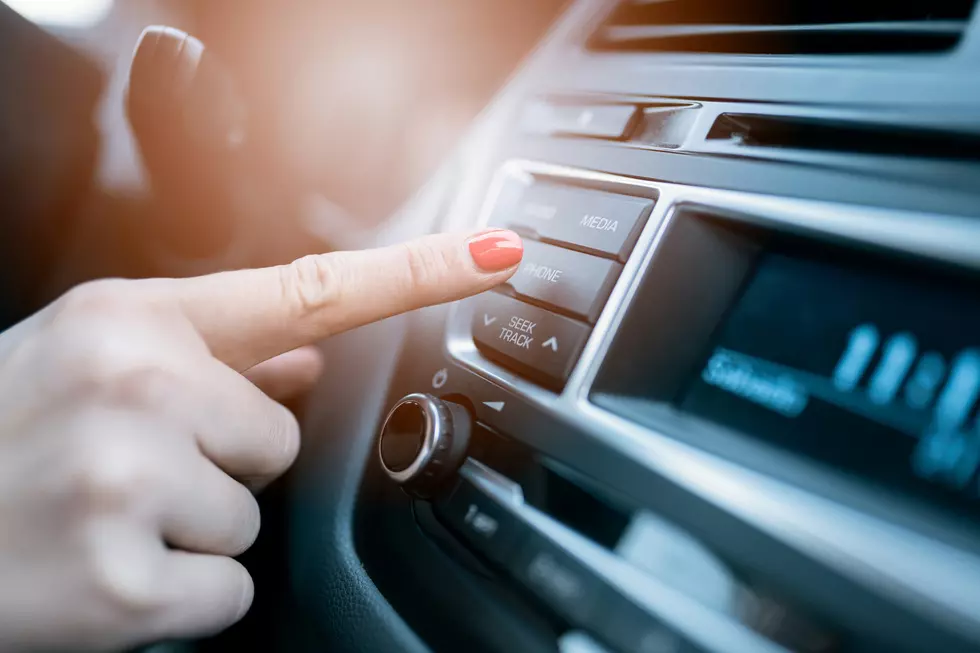 Closeup photo of woman pressing phone control button on car media system