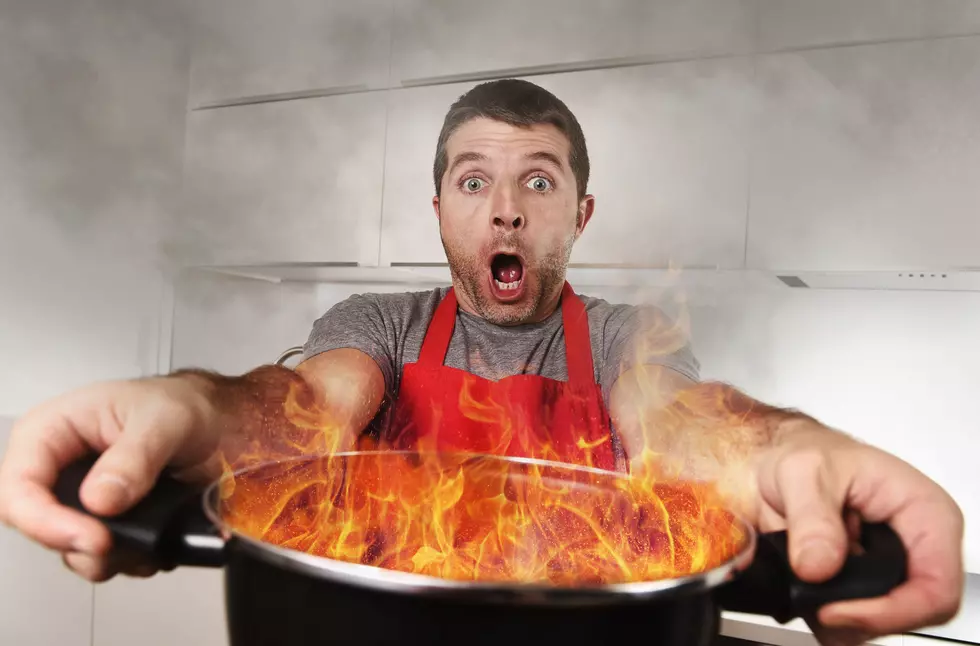 inexperienced home cook holding pot burning fire in panic stress