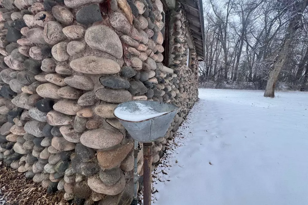 An old water fountain sits at the corner of the stone building
