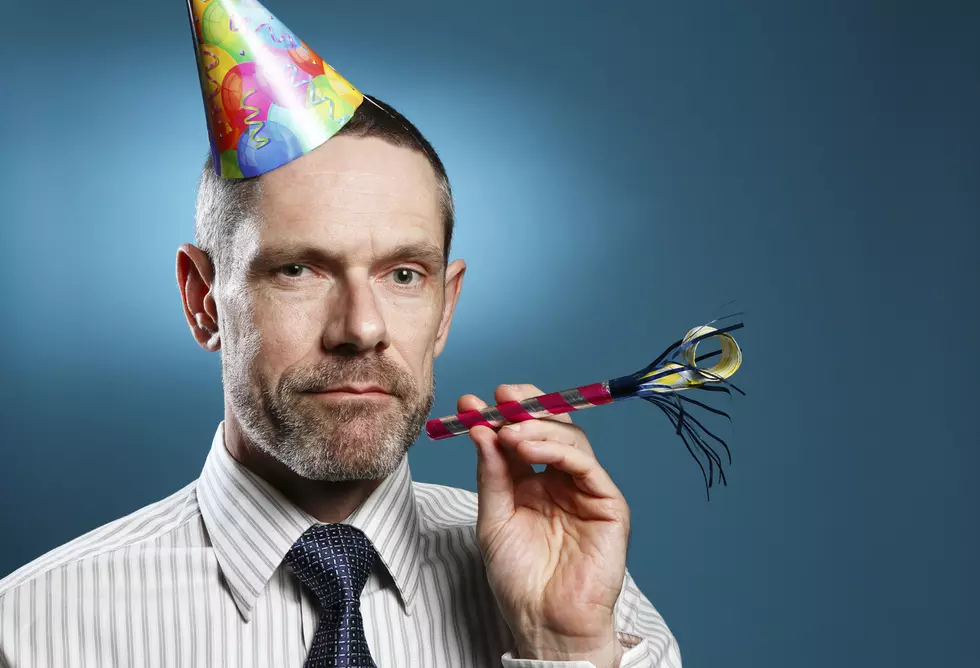Man Wearing Tie With Party Hat And Horn Blower