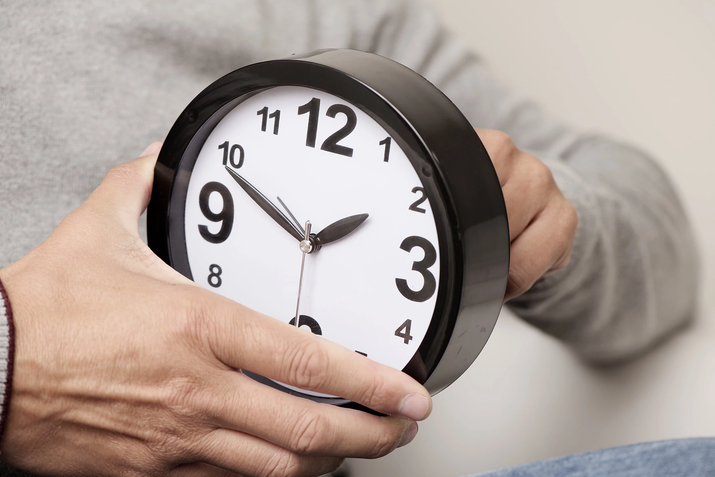 man adjusting the time of a clock