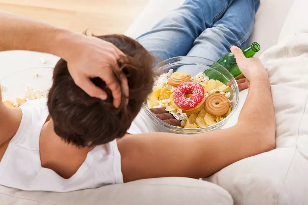 A man relaxing on a couch with sweets and beer
