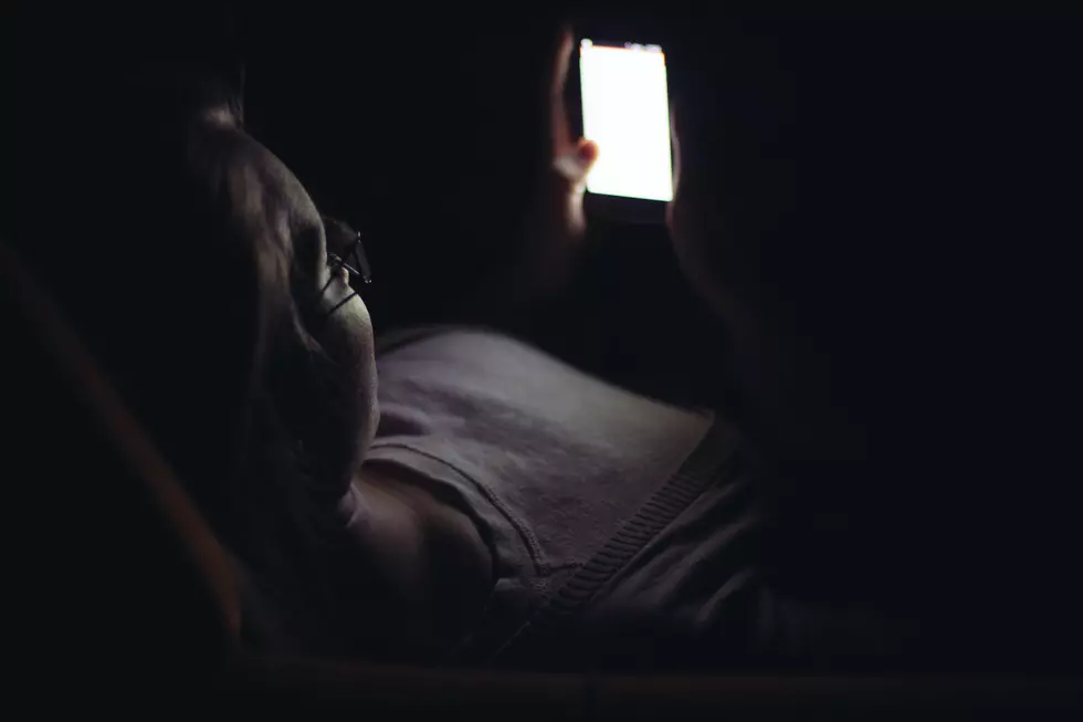 Young woman using mobile phone in dark room at night