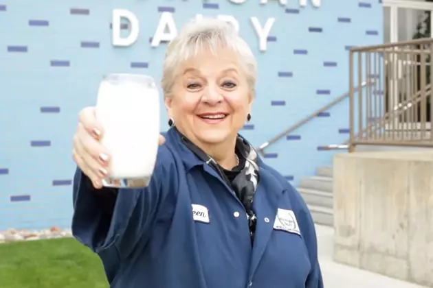 This Michigan Dairy Produces 100,000 Gallons of Milk a Day 8 A Kroger Michigan Dairy employee smiles as she extends a glass of milk towards the camera.