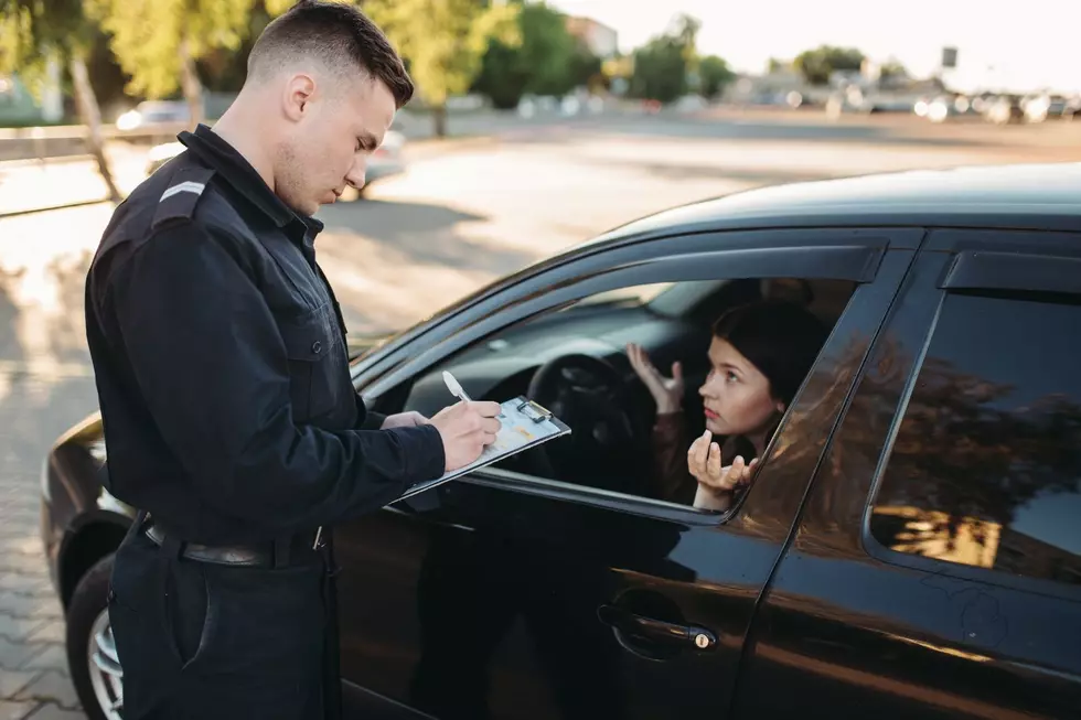 A police officer writes a woman a ticket for cutting through a parking lot in Michigan to avoid a long wait at a stoplight.