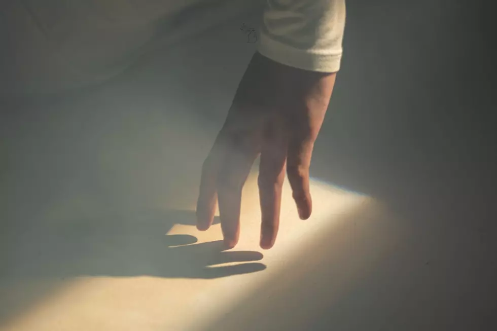A hand touches a ray of light