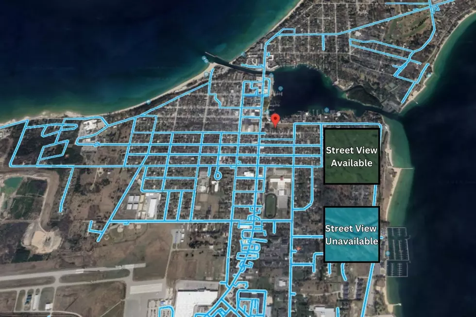 A screenshot of Google Earth showing Charlevoix, Michigan with a pin placed on the location of JonBenet Ramsey's family's former home.