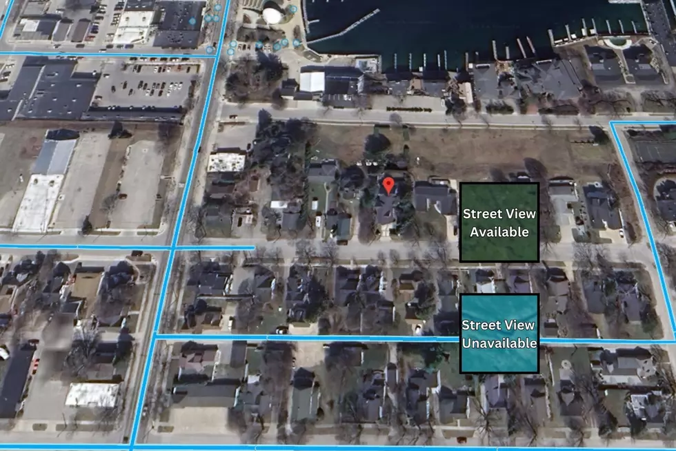 A screenshot of Google Earth showing Charlevoix, Michigan with a pin placed on the location of JonBenet Ramsey's family's former home.