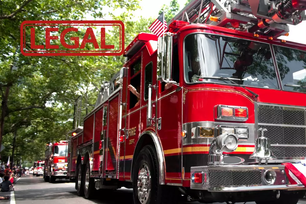 A firetruck is seen in a parade route with the word LEGAL stamped on it.