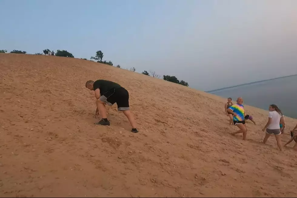 A visitor to Michigan's Sleeping Bear Dunes attempts the 450 foot climb up from the beach at the bottom of Outlook #9.