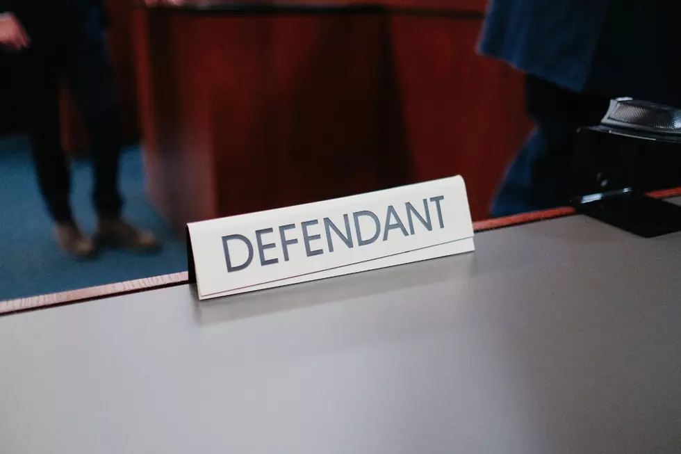 A courtroom table with a plaque reading DEFENDANT