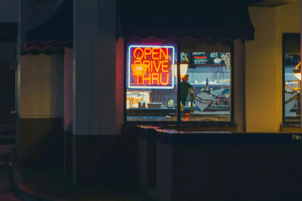 A restaurant window with a neon OPEN DRIVE THRU sign.