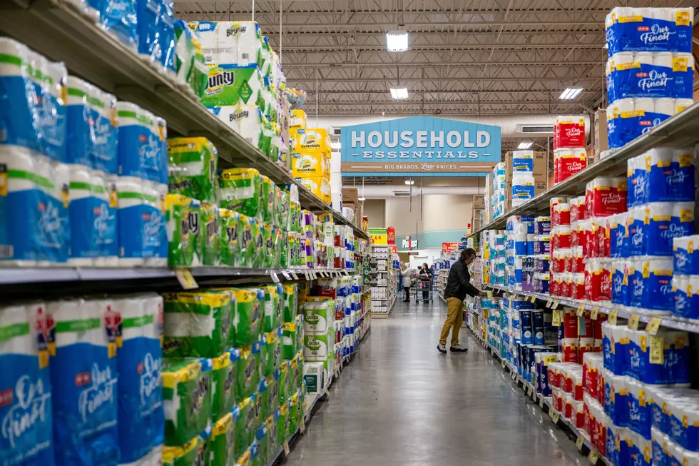 The household aisle of a grocery store with toilet paper on the right and paper towels on the left.