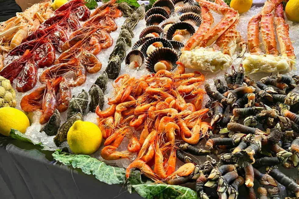 A table full of seafood on a bed of ice.