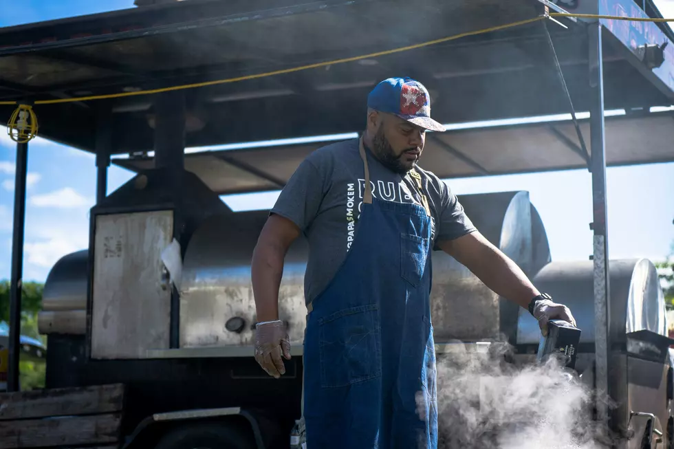 A man tends to a grill during a cookout.