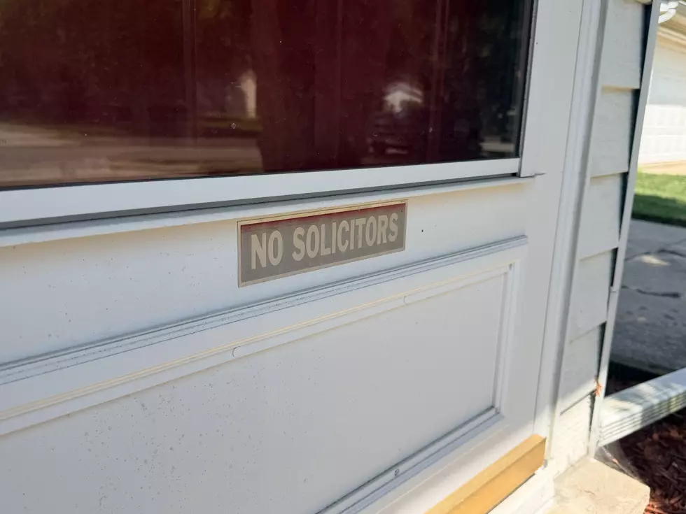 A storm door with a faded NO SOLICITORS sign.
