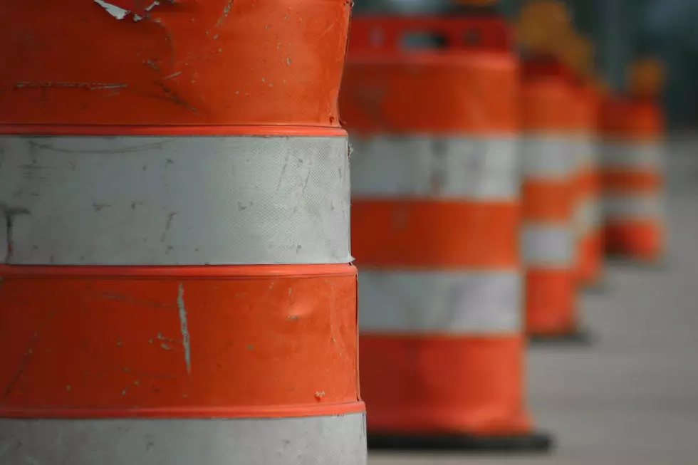 Orange barrels are seen in a row.