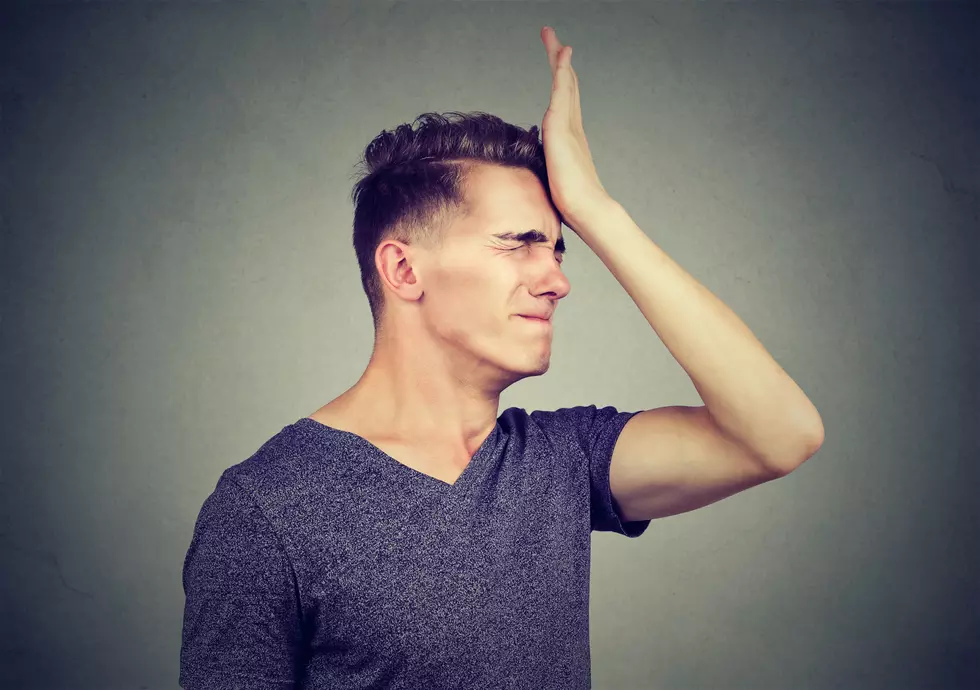 Man slapping hand on head having regrets isolated on gray background. Negative human emotion feeling