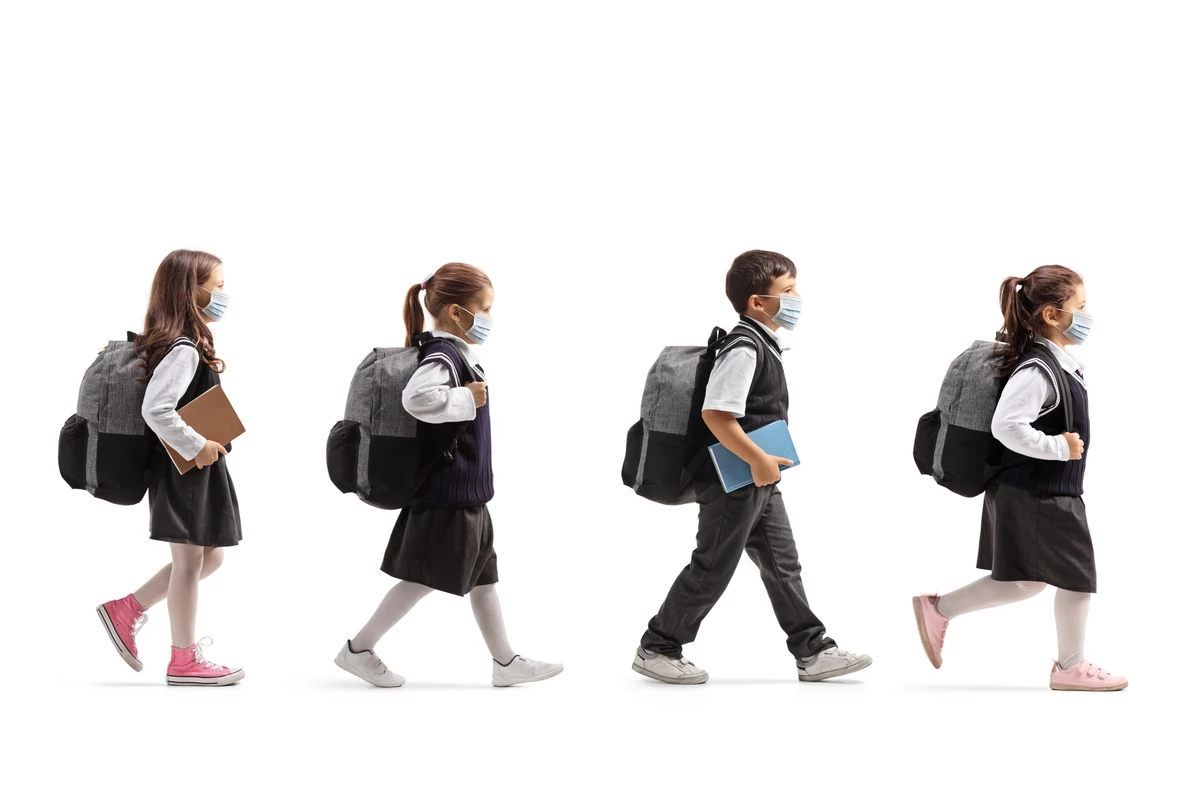 Школа в погоне. Школьник идет на белом фоне. Девочка в школьной форме с рюкзаком. Девочка с ранцем оборачивается. Дети с рюкзаками серый фон.