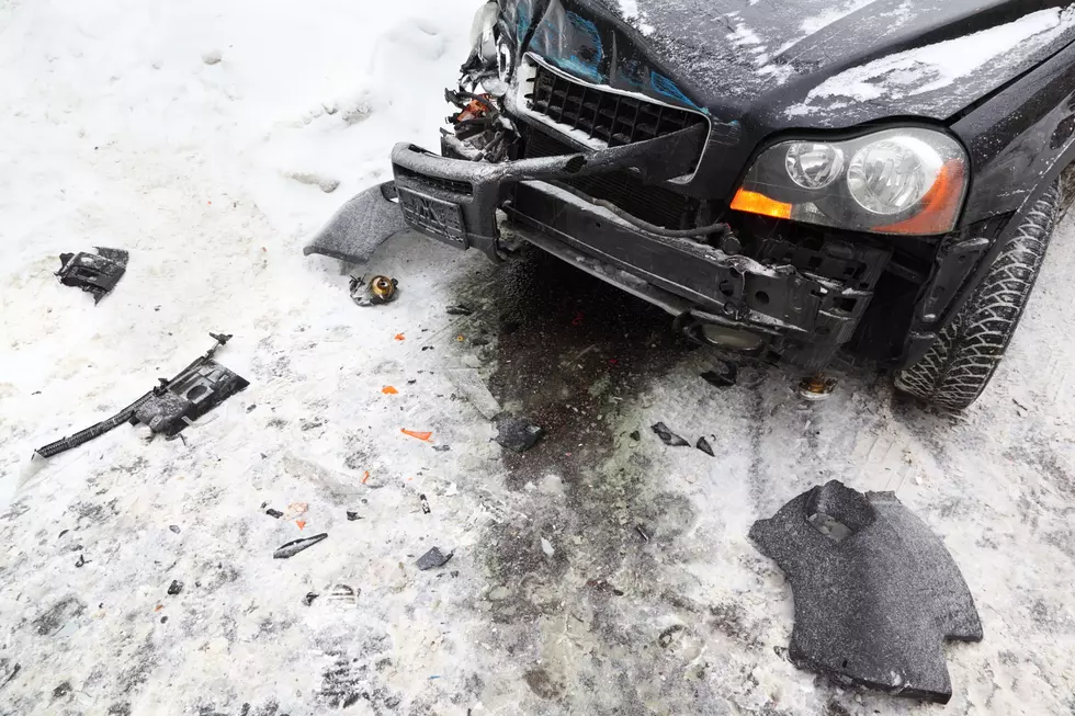 broken black car on road in winter; crash accident; crumpled hood