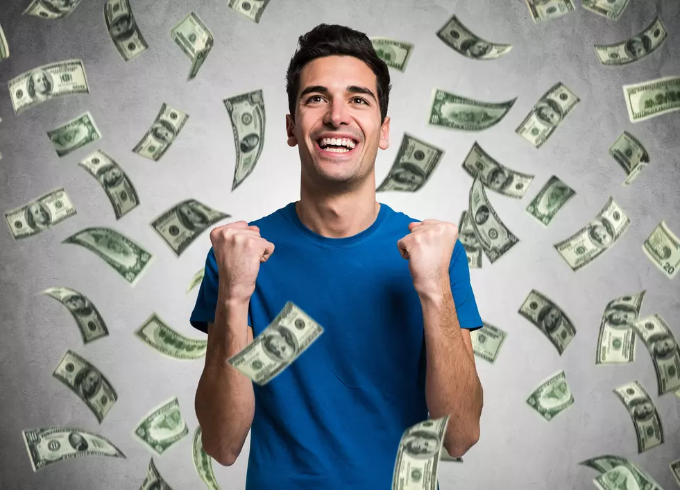 Portrait of a very happy young man in a rain of money