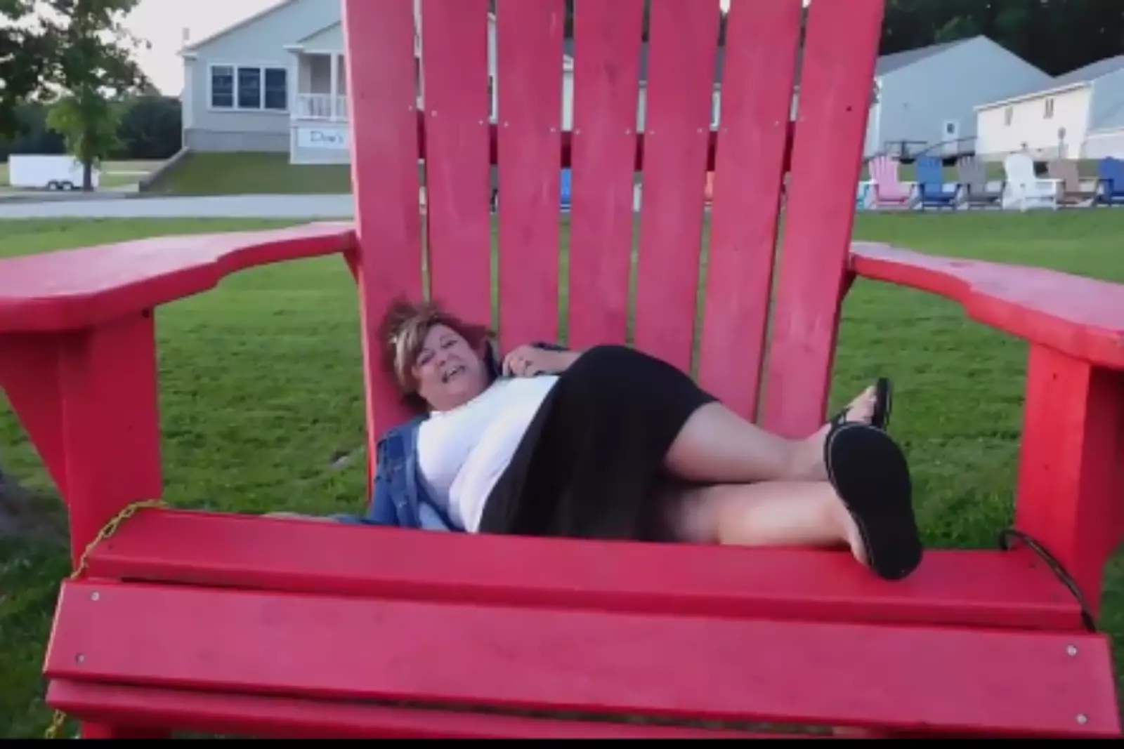 Man Sitting in Giant Adirondack Chair Stock Photo