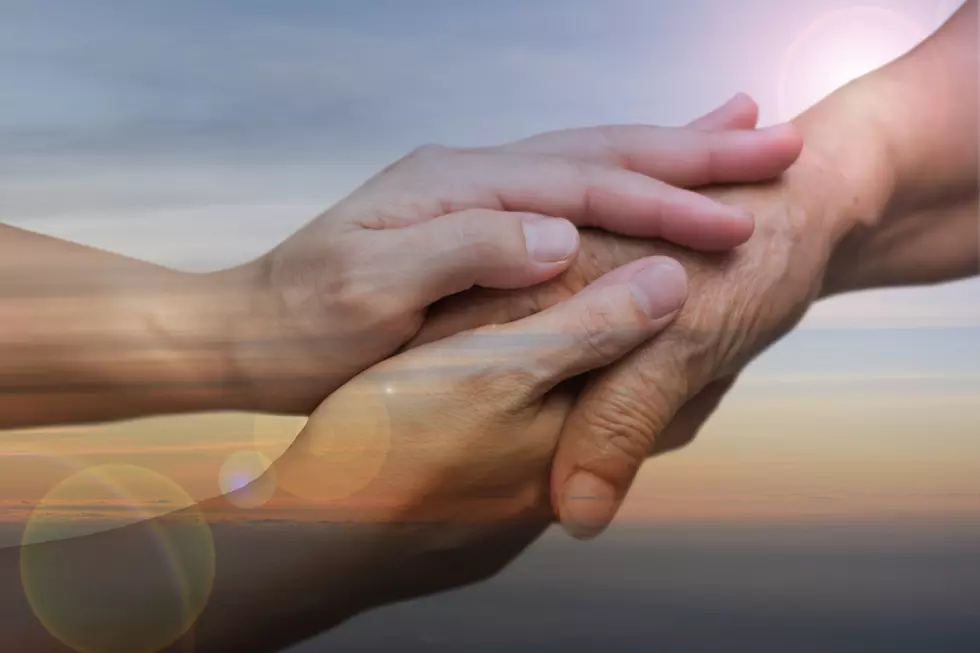 Caregiver, carer hand holding elder hand in hospice care with sky sunset background. Euthanasia Philanthropy kindness to disabled concept.
