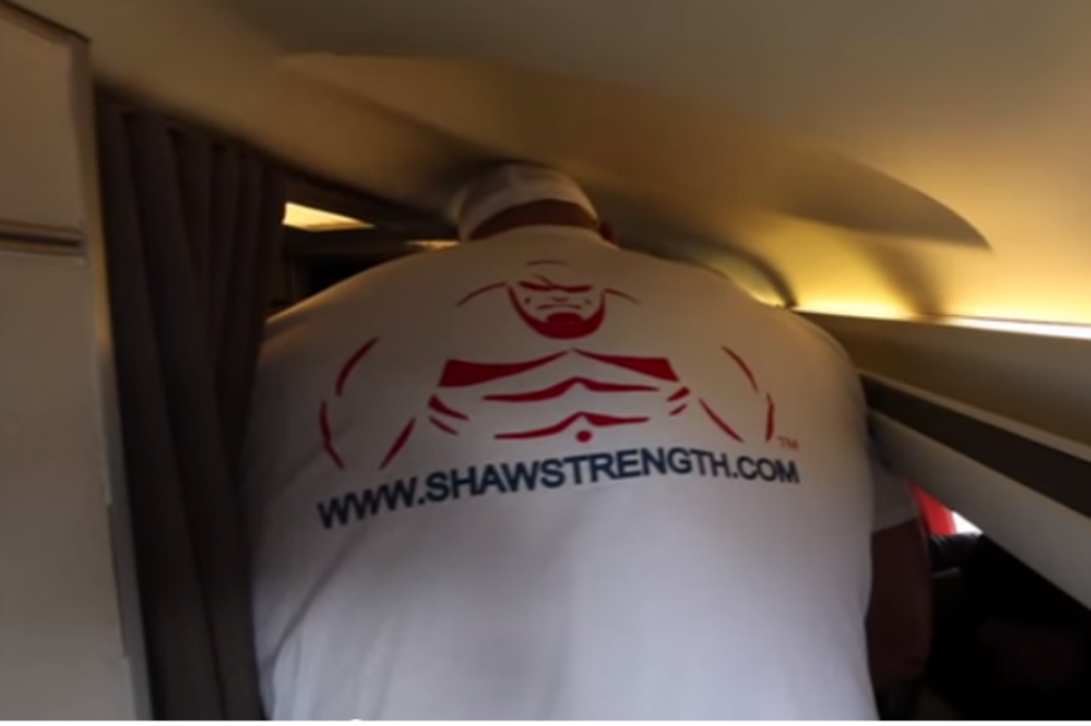 Professional Strongman Boarding Plane Will Make Claustrophobic [VIDEO]