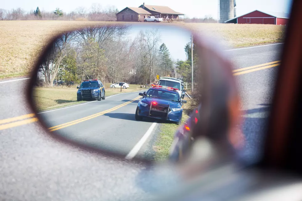Police car on road with flash lights and siren at day