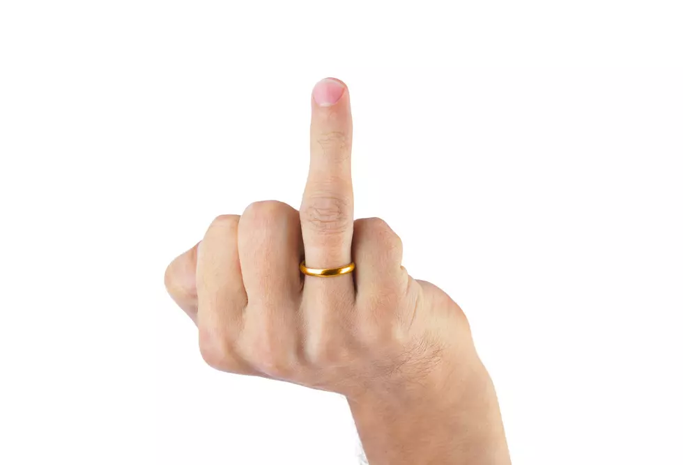 Hand showing middle finger with wedding ring isolated on white background