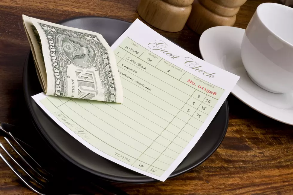 Restaurant guest check with folded dollar bills