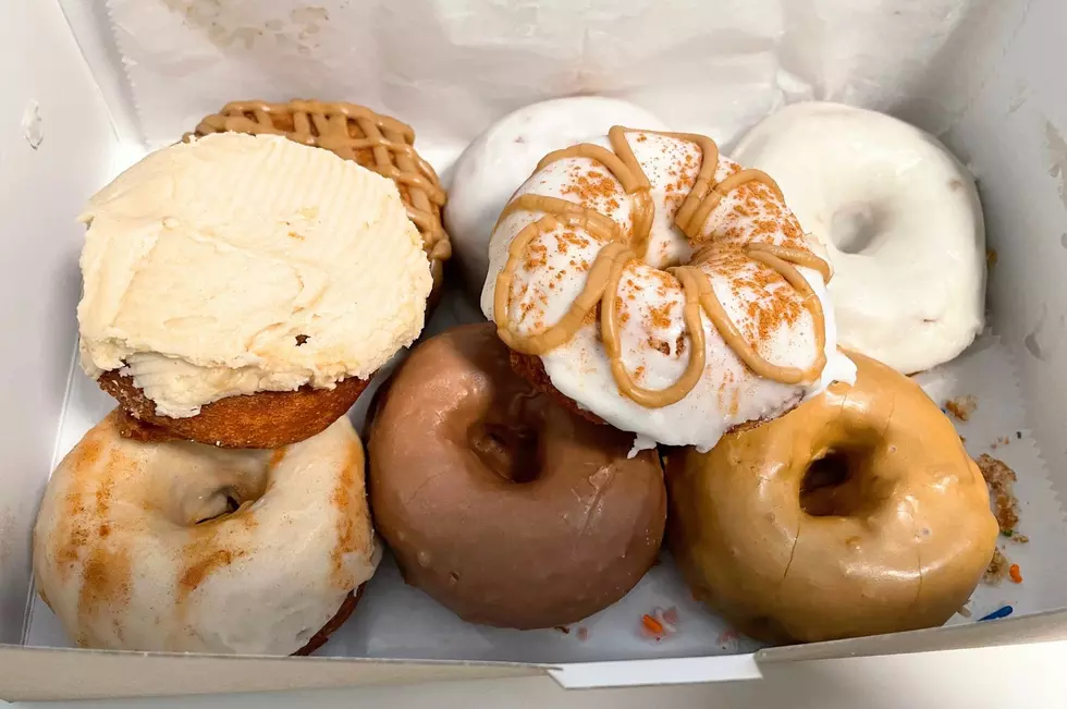 A bos of apple cider donuts with frosting