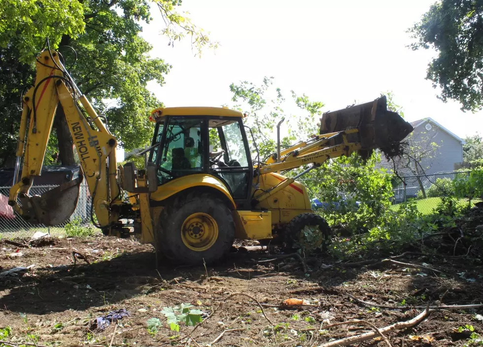 Construction vehicles moving debris off of vacant lot in Poughkeepsie