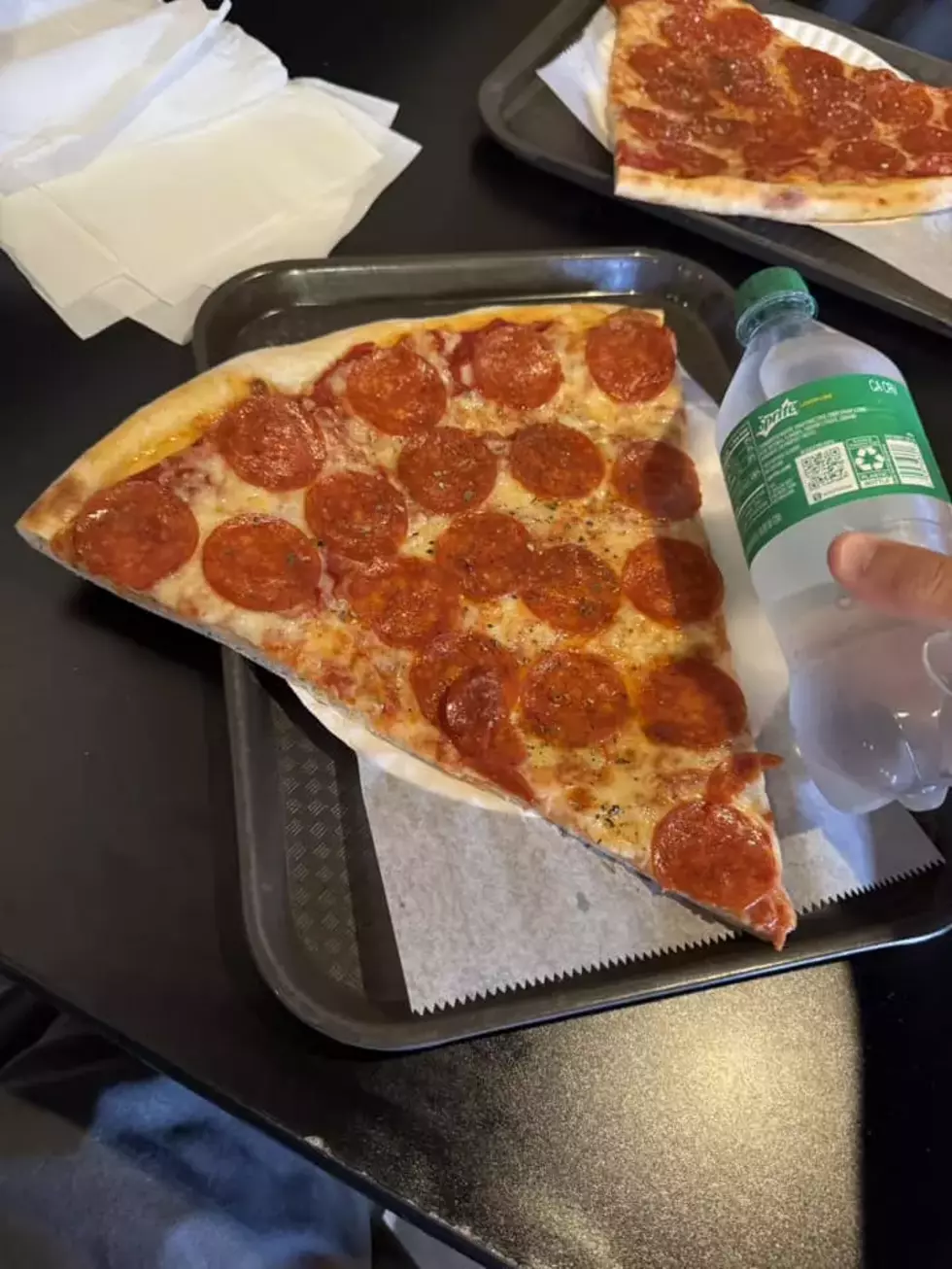 A slice of pizza from Longobardi's next to a 20 oz soda for scale. Photo credit. A. Boris