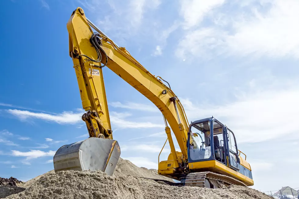 Excavator is preparing pile of sand for loading in truck.
