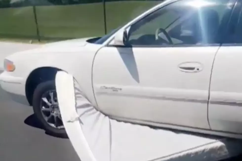 Car Drives Down Highway with Mattress Stuck Underneath