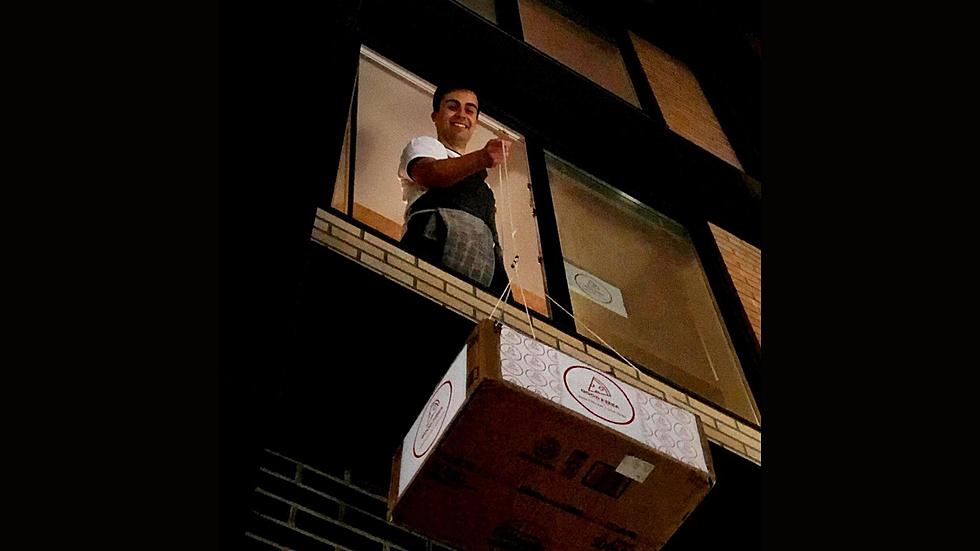 Man Gives Away Hundreds of Free Pizzas For Charity, Lowering Them From Apartment Window