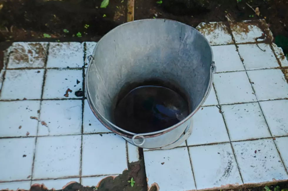 Empty buckets of water that do not contain water over worn and dirty ceramics