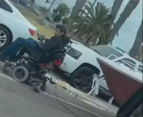 Man Stops Traffic While Towing Boat With Electric Wheelchair