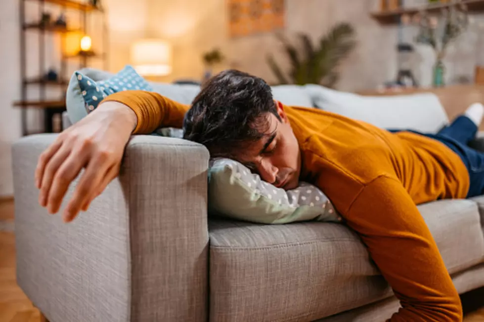 Tired young man falling asleep on the sofa in the living room.