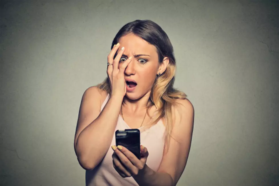 anxious scared girl looking at phone seeing bad news