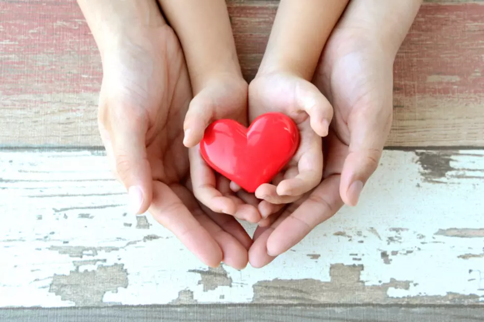 Red heart in child and mother's hands