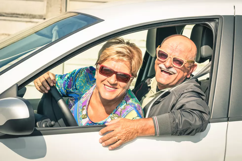 Happy senior couple driving car on a journey trip