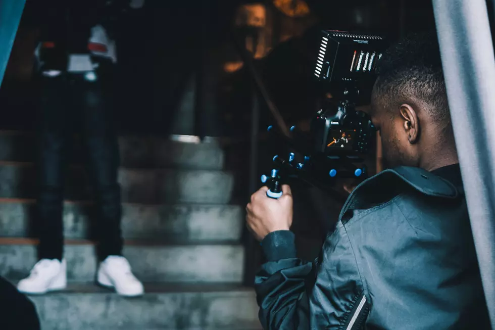 a man holding a camera filming someone walking down stairs