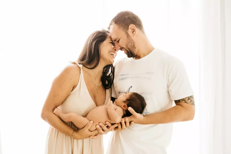 a couple holding their baby with a white background